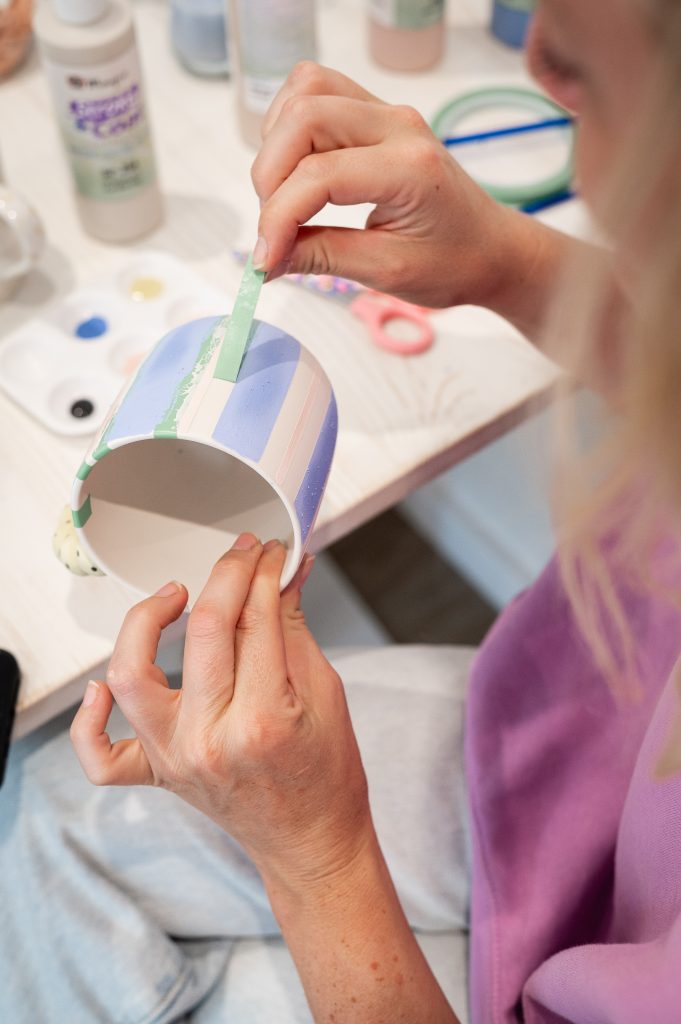 Personne concentrée sur la décoration d’une céramique au café céramique de Biscarrosse
